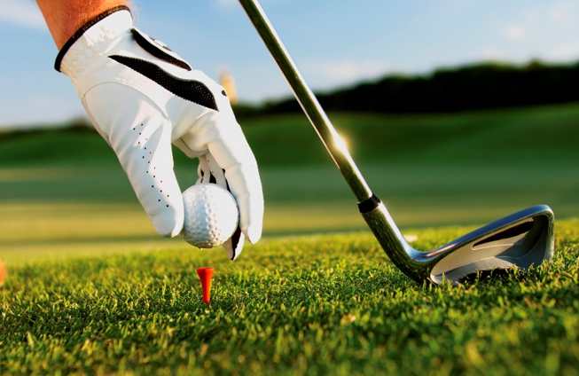 Golf ball being placed onto a driving tee