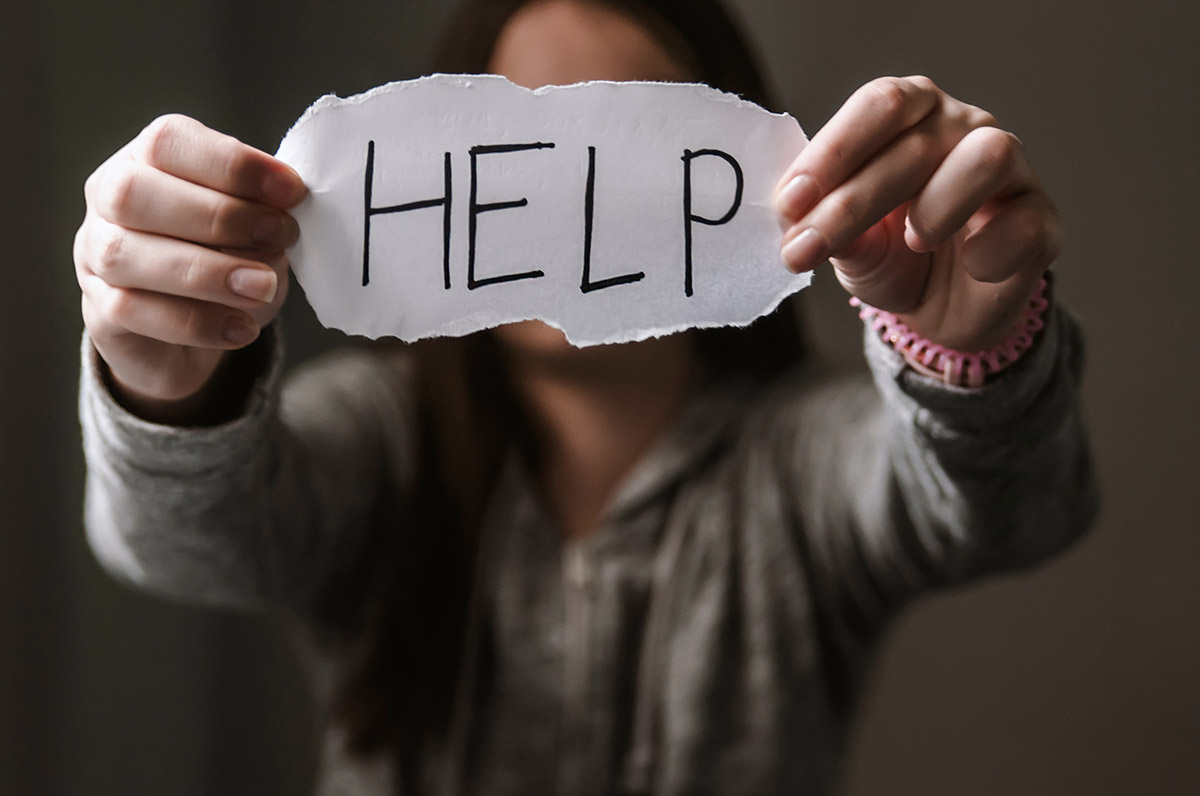 Woman holding up a 'Help' sign